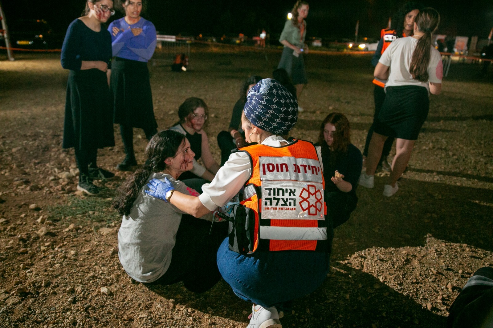 Female United Hatzalah Psychotrauma & Crisis Response volunteer comforting a group of young girls in Israel.