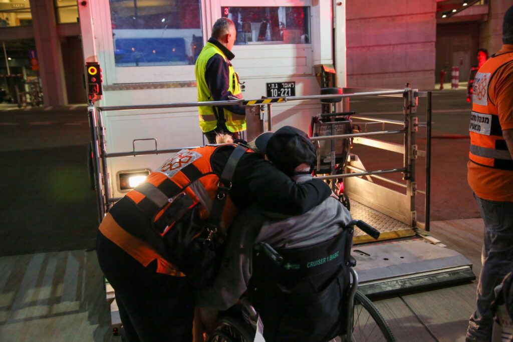 One of the evacuees being assisted off of the plane 1024x683 1