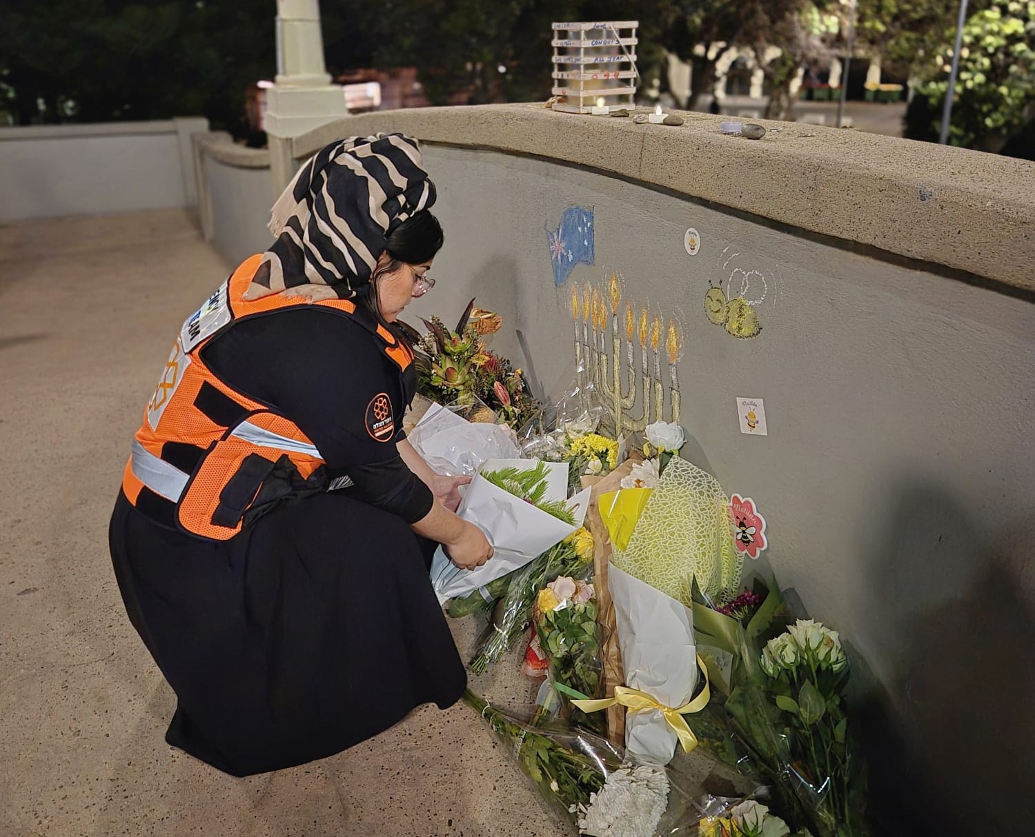 Member of United Hatzalah's Psychotrauma & Crisis Response delegation to Sydney lays a wreath by the site of the December 14 Chanukah Terror Attack in Bondi Beach